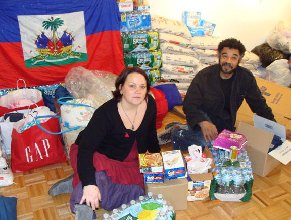 Mary Malloy/Herald
Carlo Thertus and his wife, Karen are calling on the community to help them sort items that have been donated to the Haiti Relief Fund. Behind Carlo is 500 pounds of rice that a donor from Westbury had dropped off the day before.