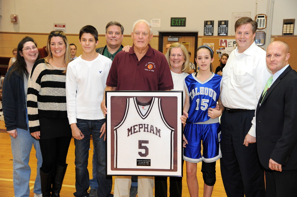 Mepham basketball great Joseph Metzger III recently had his number retired during a surprise ceremony at his alma mater. Joining him to celebrate were, from left, daughter-in-law Mary Ann Metzger, daughter Tammy McLoughlin, grandson Austin McLoughlin, son David Metzger, his wife, Joyce, granddaughter Bailey McLoughlin, son-in-law Brian McLoughlin and Mepham Principal Michael Harrington.